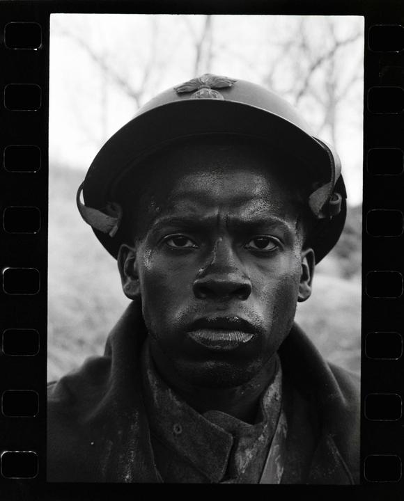 A man wearing a helmet looks directly at the viewer.