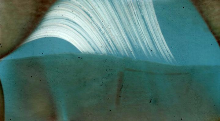 A light blue abstract shape with white streaks curves over a darker blue-green area.
