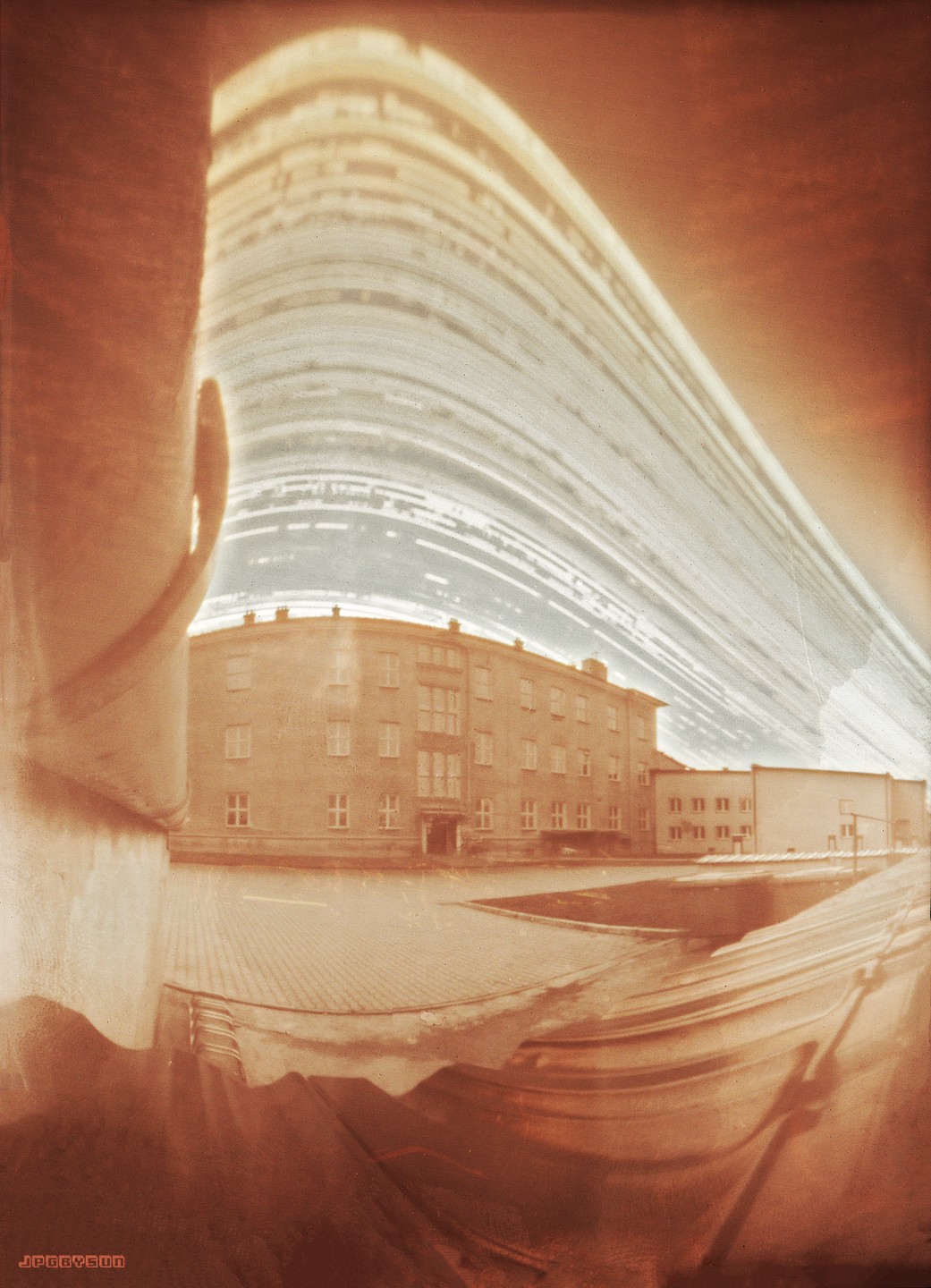 A long exposure photograph of a high school building in Poland with a distorted sky.