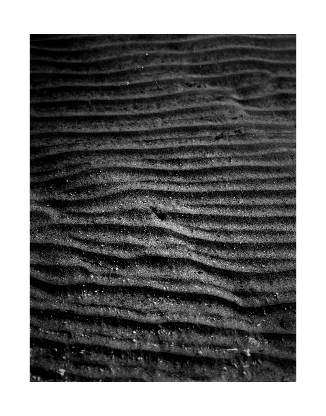 Ripples of sand are visible on the bottom of a lake.