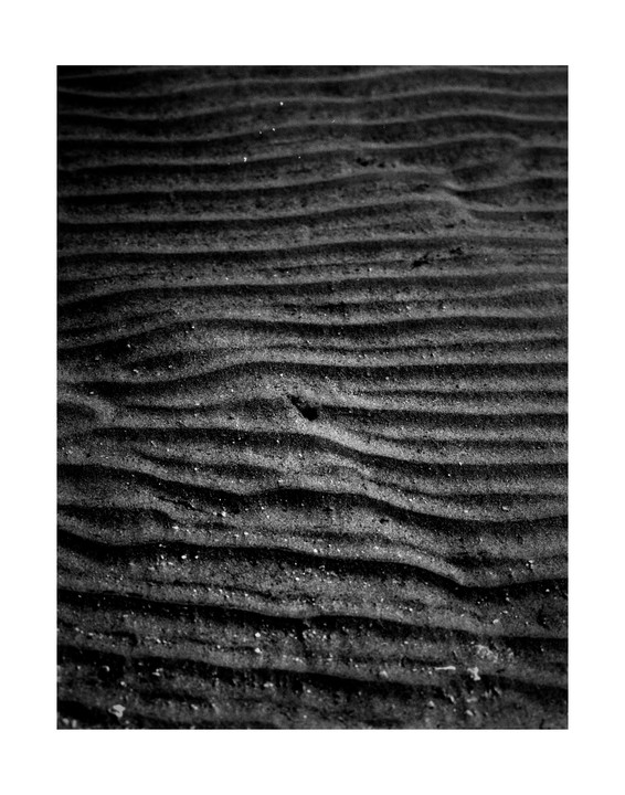 Ripples of sand are visible on the bottom of a lake.
