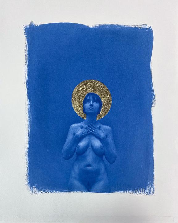 A nude woman with a gold leaf halo stands against a blue background.