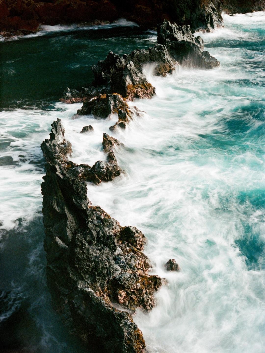 Waves crash against a rocky coastline.