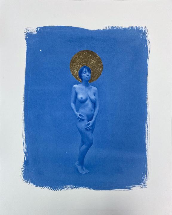 A nude woman stands with a gold leaf halo against a blue background.