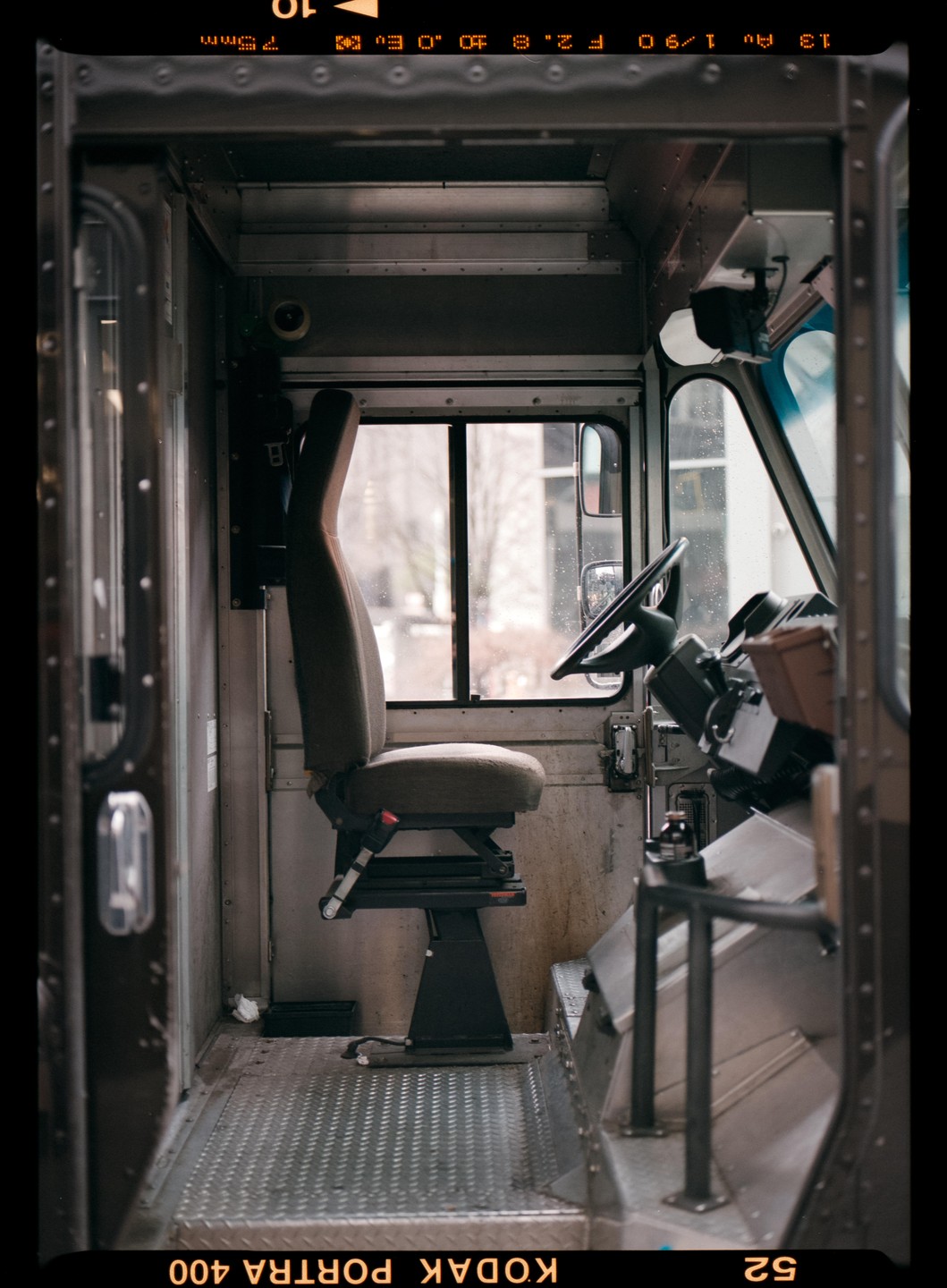 The interior of a delivery truck is visible, showing the driver's seat and steering wheel.
