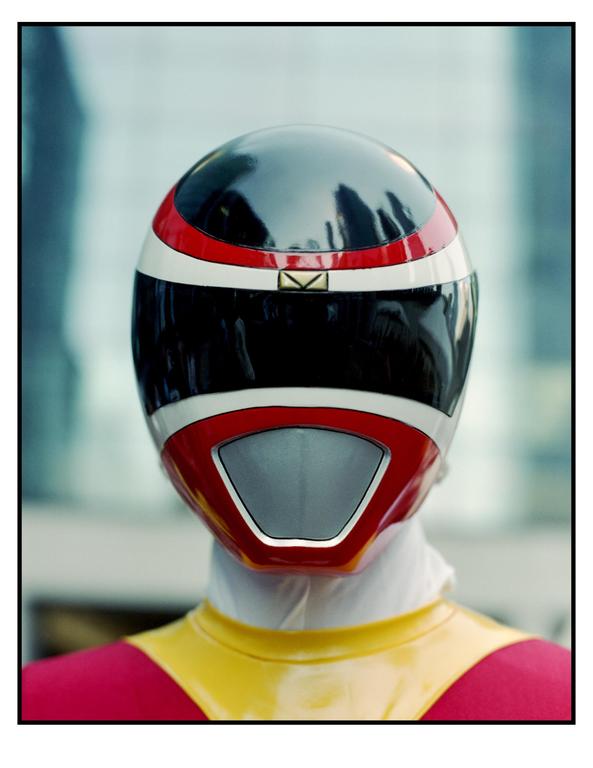 A person in a red, black, and white helmet with a yellow and red suit is shown from the shoulders up.