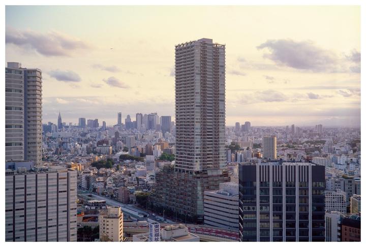 A panoramic view of a city skyline with numerous buildings and a cloudy sky.
