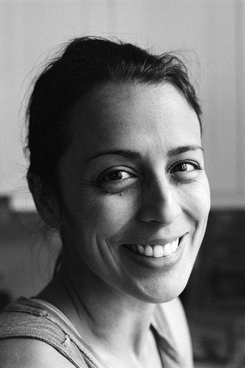 A woman with dark hair smiles at the viewer.
