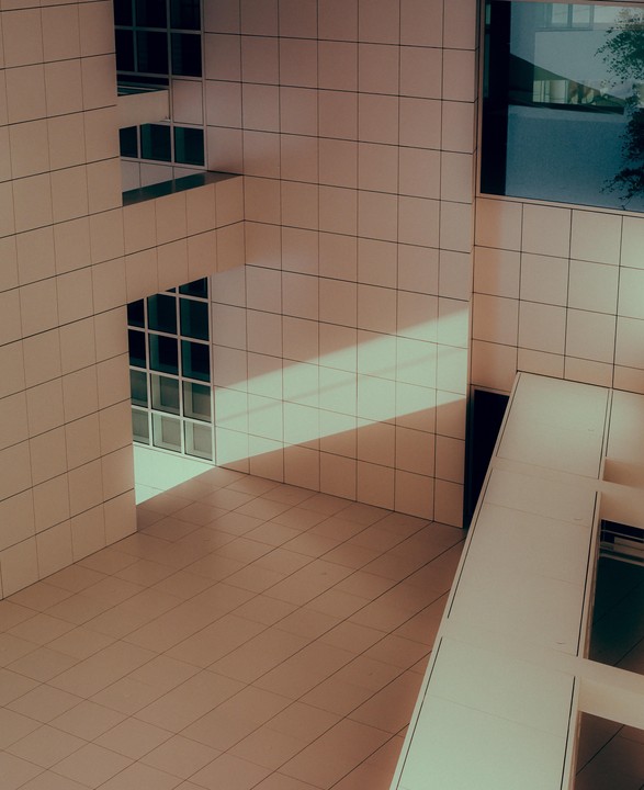Sunlight illuminates a tiled building with multiple windows and balconies.