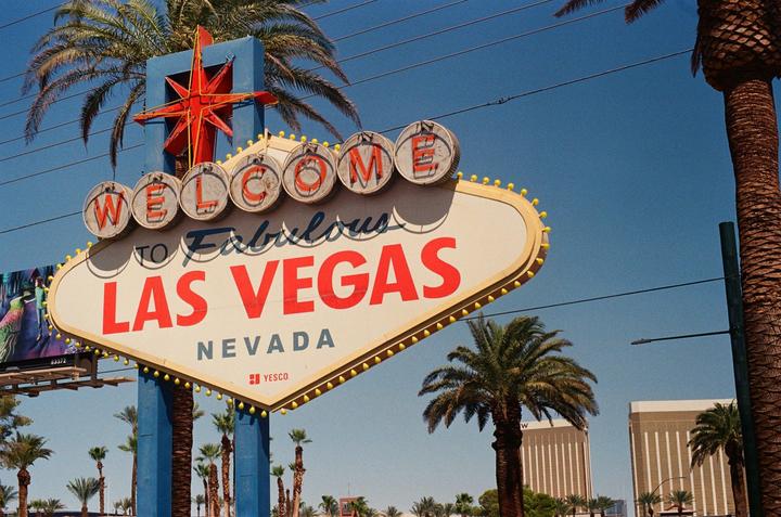 The Welcome to Fabulous Las Vegas sign stands prominently against a clear blue sky, surrounded by palm trees.