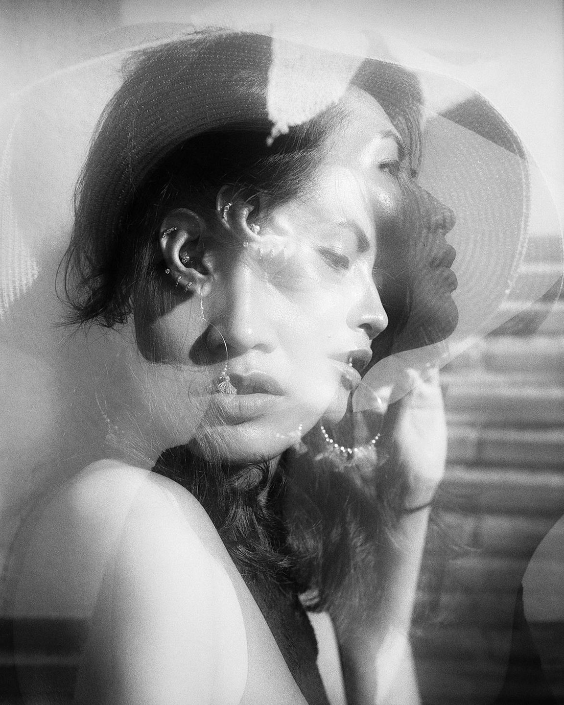 A woman with a hat is shown in a triple exposure with her eyes closed and open.
