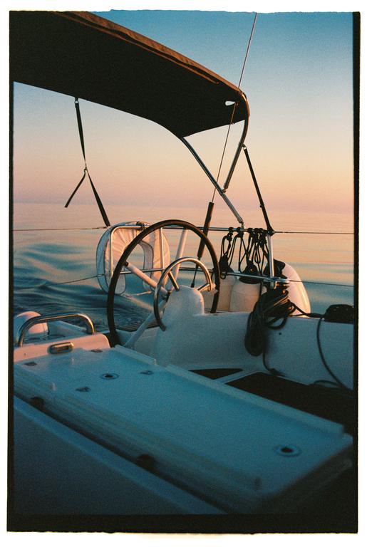 A sailboat is on the water at sunrise.