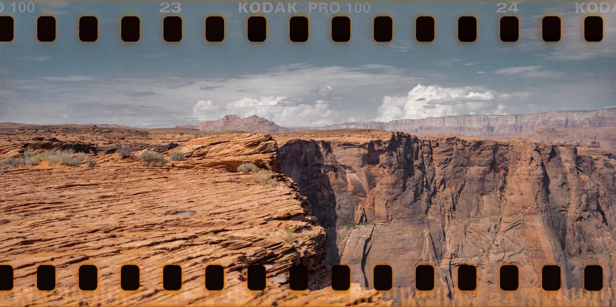 A wide view shows the Horseshoe Bend canyon with a cloudy sky above.