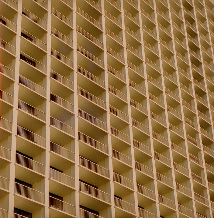 The side of a building is covered in many identical balconies.