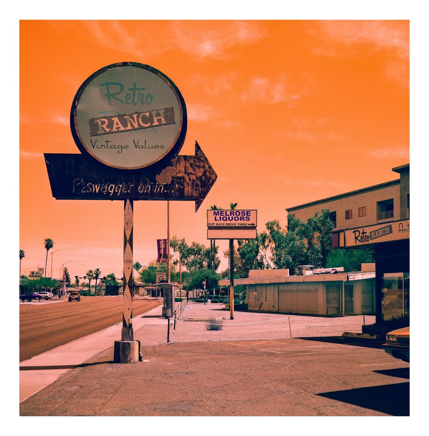 A street scene shows a large sign for "Retro Ranch" with an arrow pointing towards a building, and another sign for "Melrose Liquors" in the background.