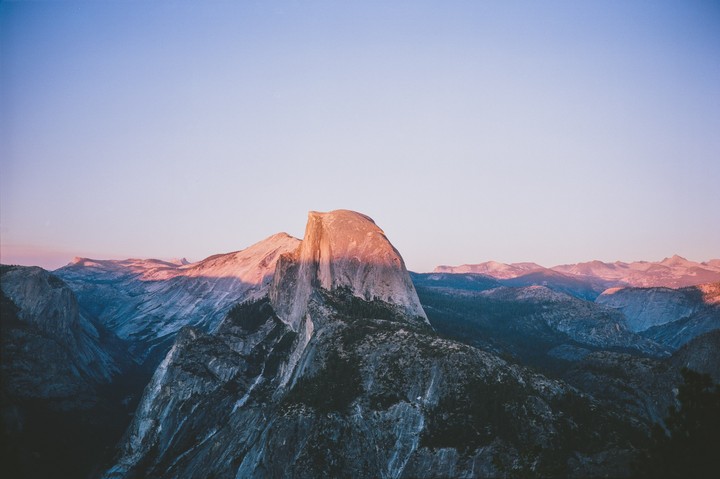 The last rays of sun illuminate the Half Dome mountain in Yosemite National Park.