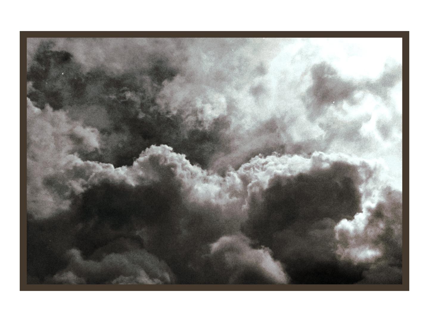 A dramatic sky is filled with dark, heavy clouds and bright highlights.