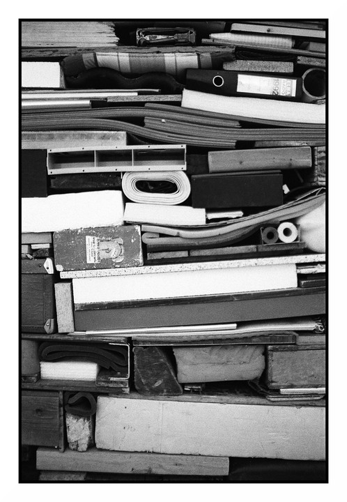 A variety of objects are stacked tightly together, creating a textured wall of different shapes and materials.