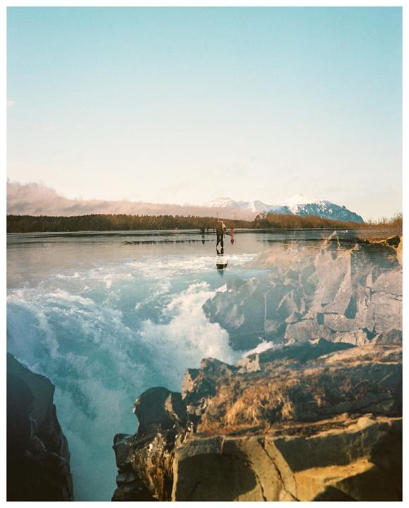 A double exposure shows a person ice skating on a frozen lake with mountains in the background, superimposed over a waterfall and rocks.