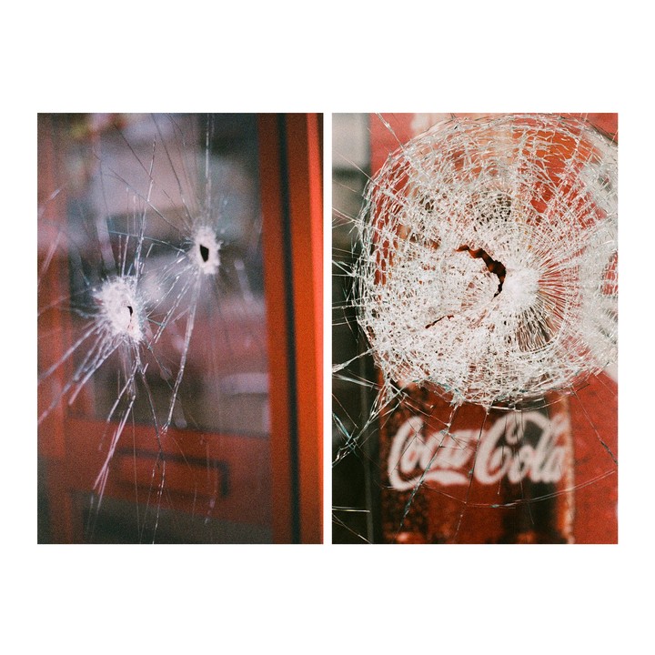 Two images show broken glass, one with two bullet holes and the other with a single impact point over a Coca-Cola machine.