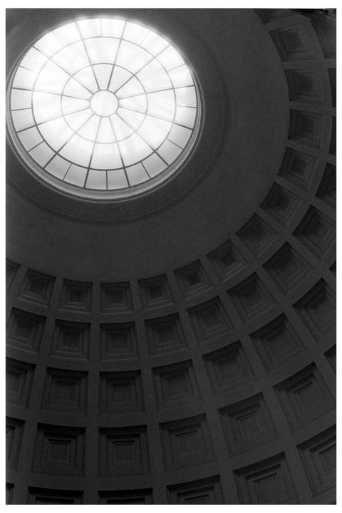 A large circular skylight illuminates a domed ceiling with square coffers.