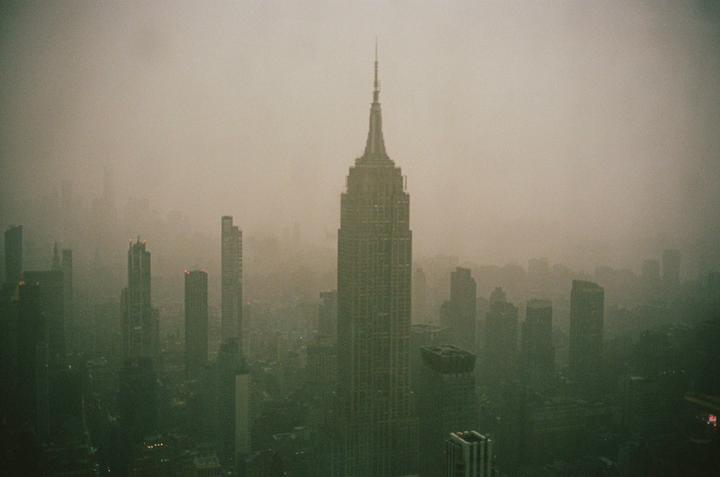 The Empire State Building rises above the hazy New York City skyline.
