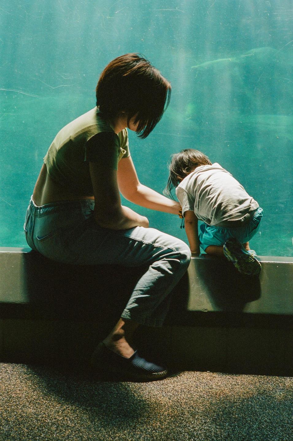 A woman and a child look into a large aquarium.