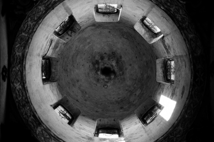 A high-angle view shows the inside of a dome with several windows and a dark opening at its center.