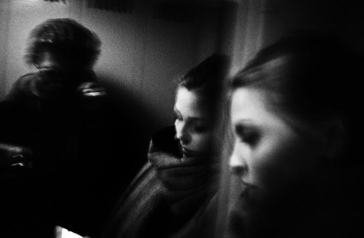 Three women are visible in a dark, grainy, black and white image.