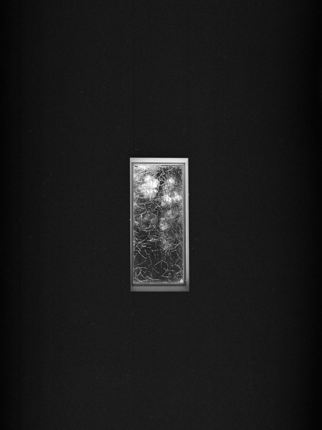 A small, rectangular frame with a textured, abstract pattern is centered on a dark background.