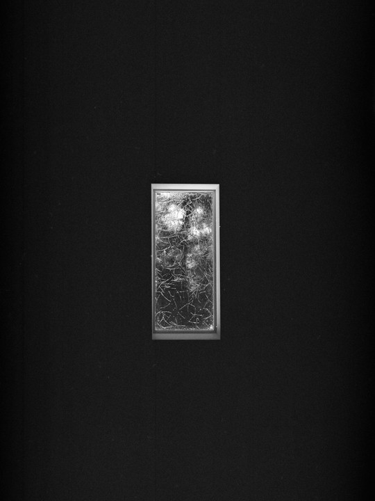 A small, rectangular frame with a textured, abstract pattern is centered on a dark background.