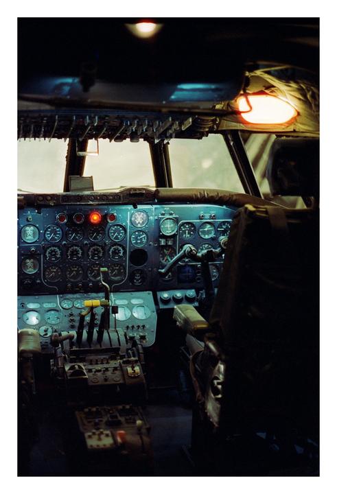 The cockpit of an airplane is visible with many gauges and controls.