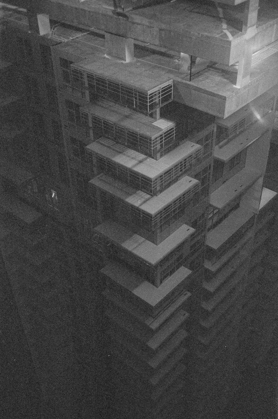 An architectural model of a tall building with many balconies is viewed from above.