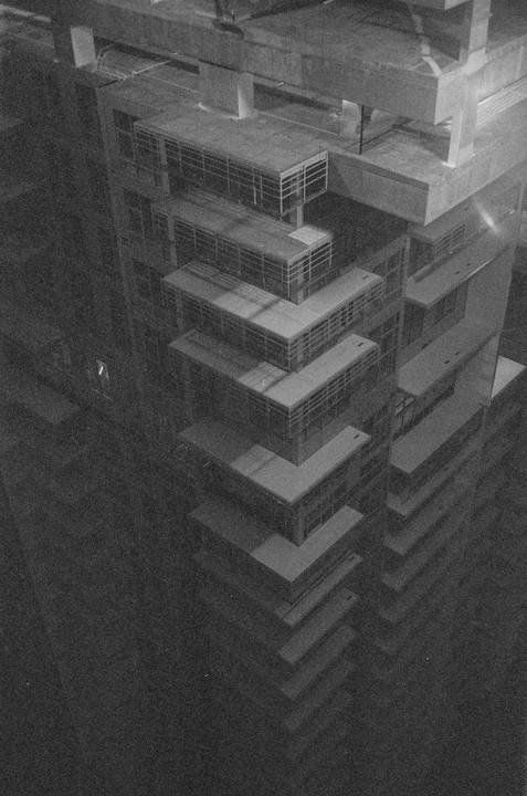 An architectural model of a tall building with many balconies is viewed from above.