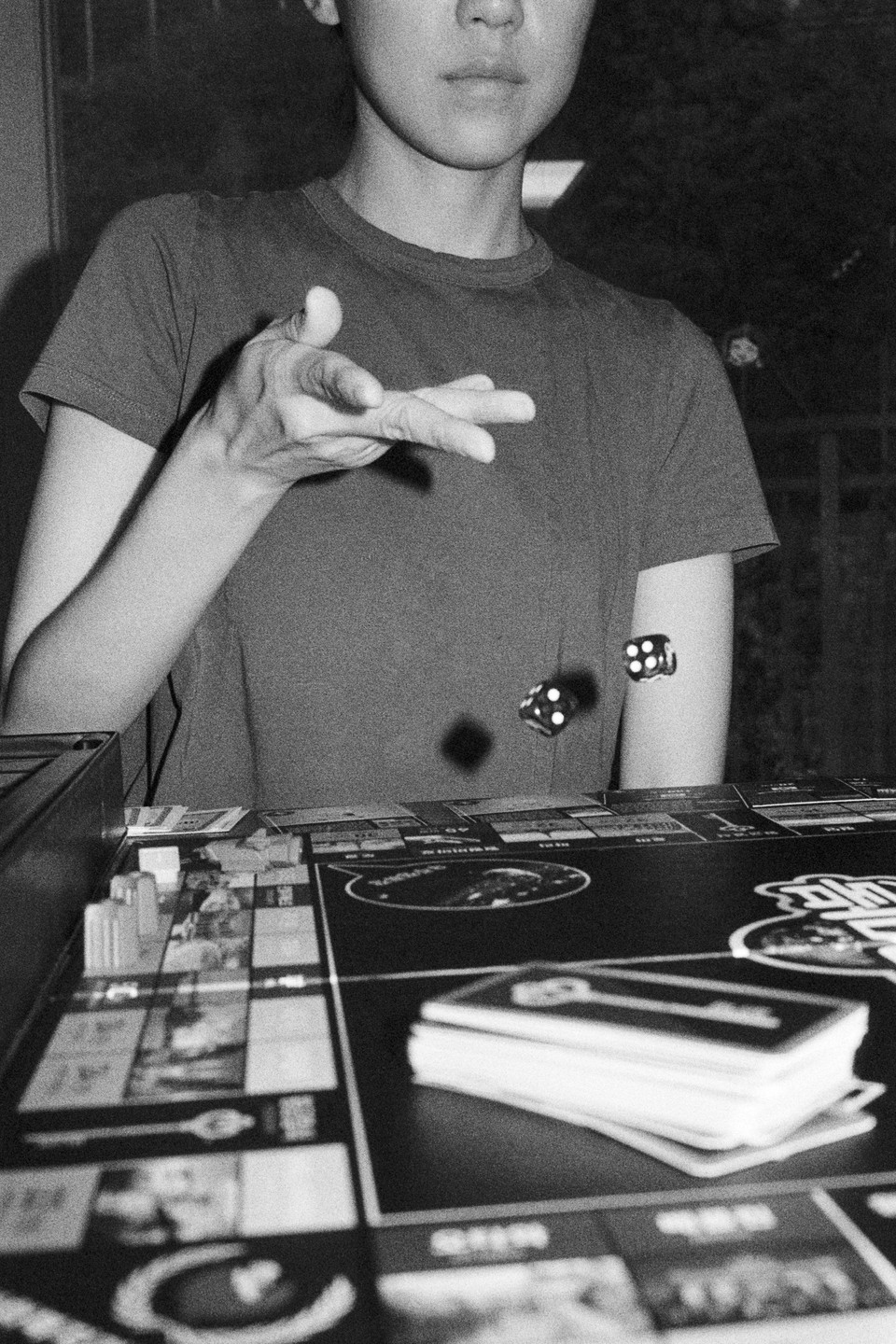 A person rolls dice over a board game.