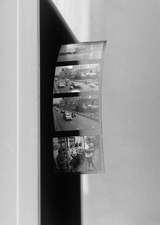A strip of four black and white negatives is displayed against a white background with a shadow.