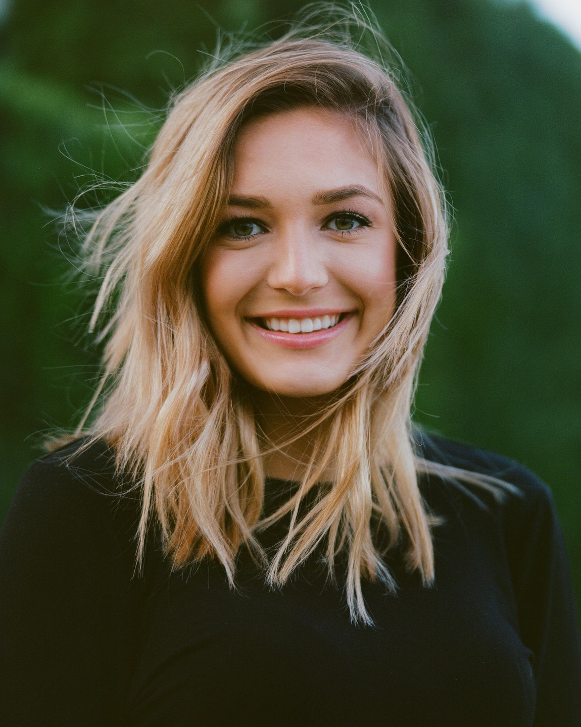 A woman with blonde hair smiles at the viewer.