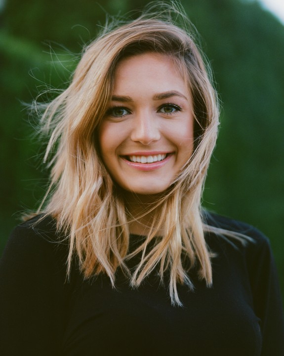 A woman with blonde hair smiles at the viewer.
