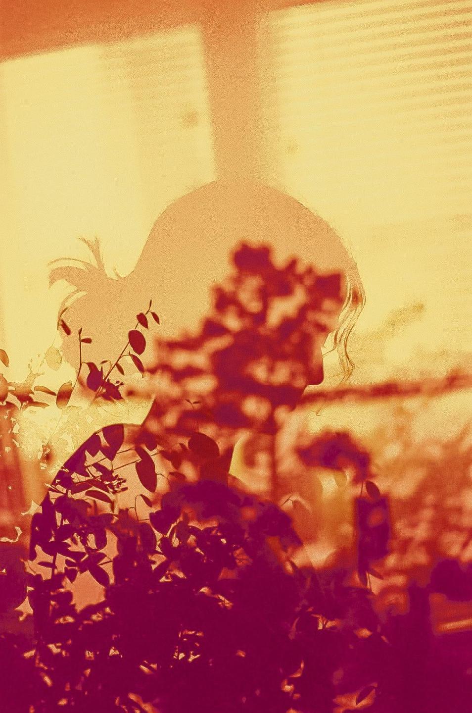 A double exposure shows the silhouette of a woman overlaid with foliage.