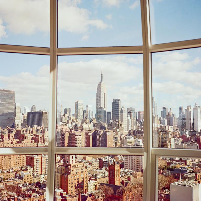 A cityscape with the Empire State Building visible through a window.
