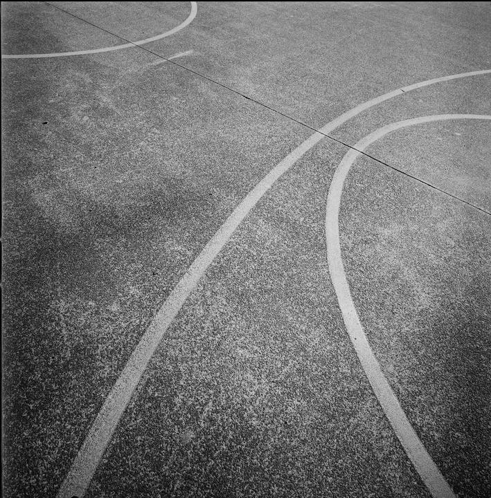 White lines curve across a textured basketball court.