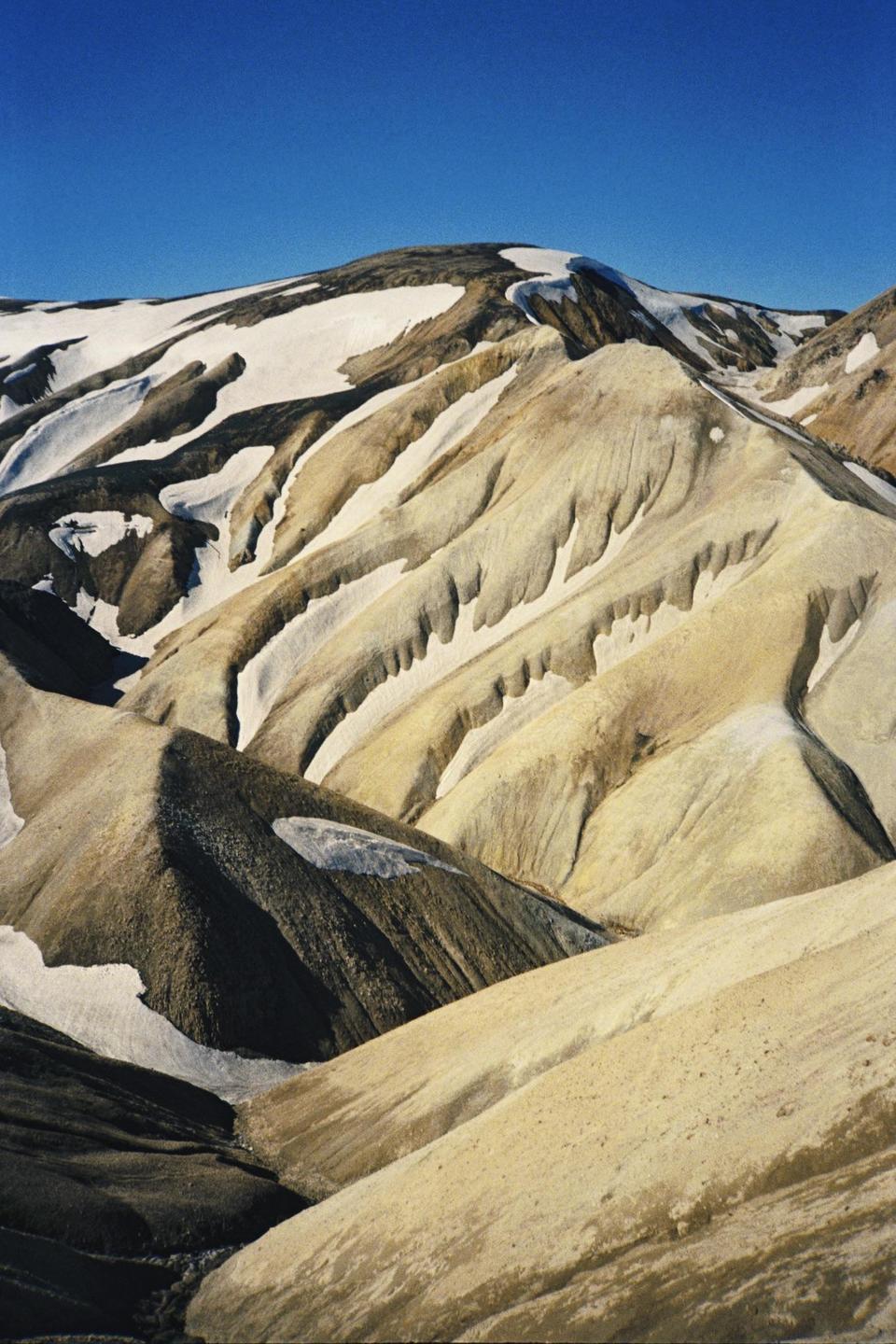 Snow covers the peaks and valleys of the colorful rhyolite mountains of Landmannalaugar.