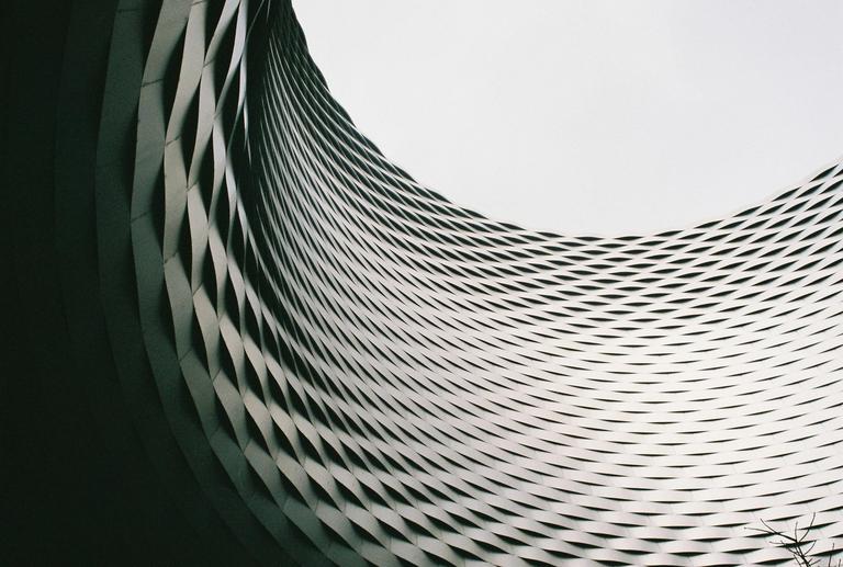 A curved, textured wall with a diamond pattern is visible against a bright background.