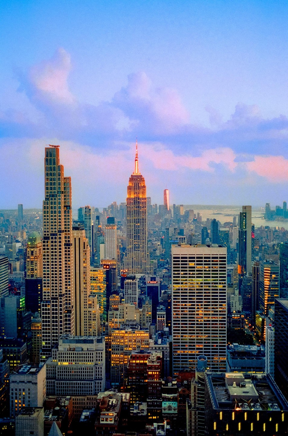 The Empire State Building and other skyscrapers are illuminated at dusk in New York City.