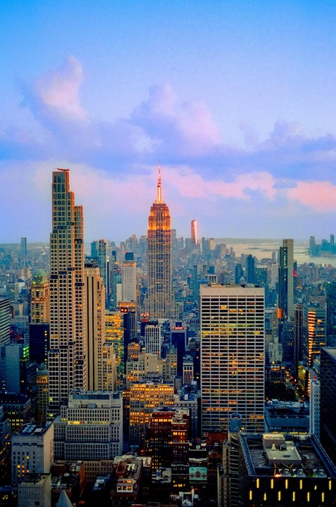 The Empire State Building and other skyscrapers are illuminated at dusk in New York City.