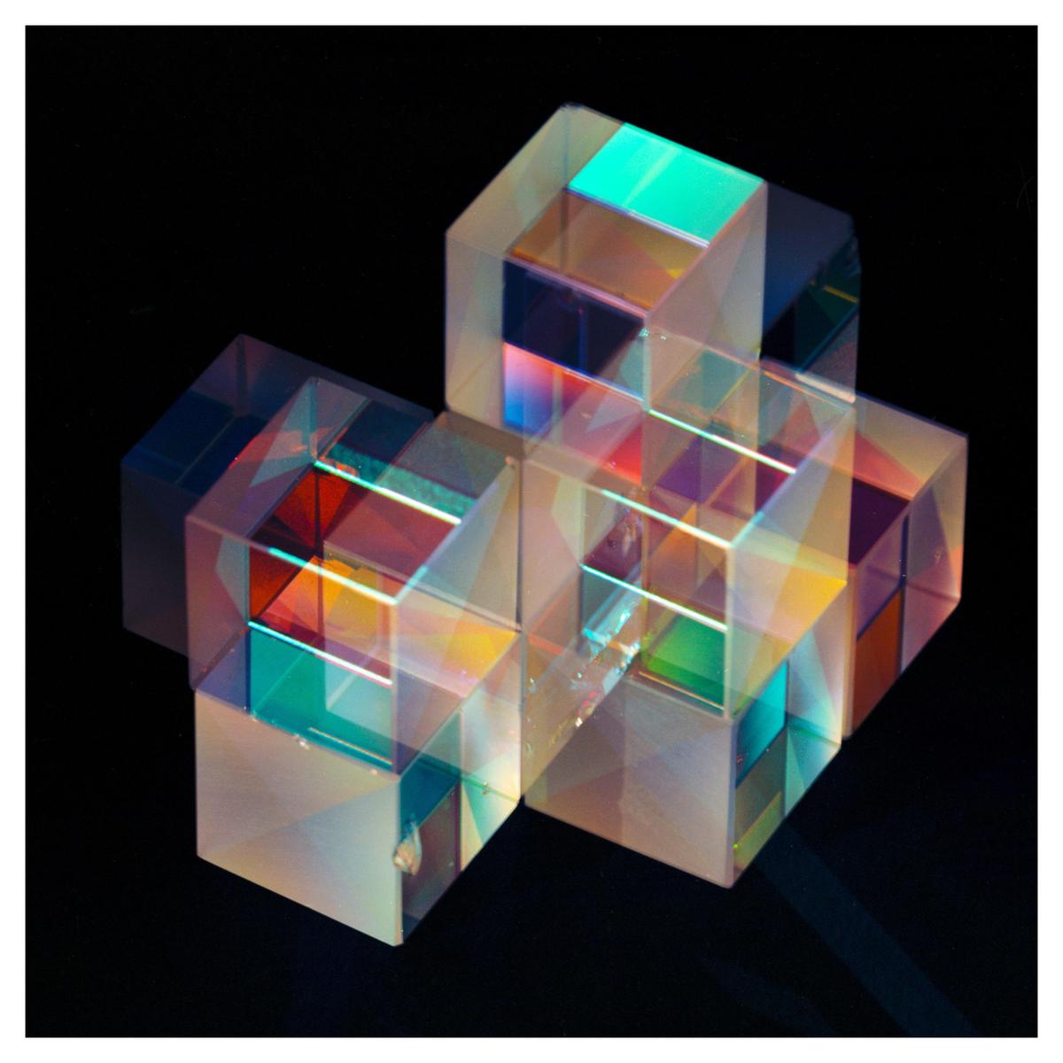 A cluster of translucent cubes reflects and refracts light, creating colorful patterns.