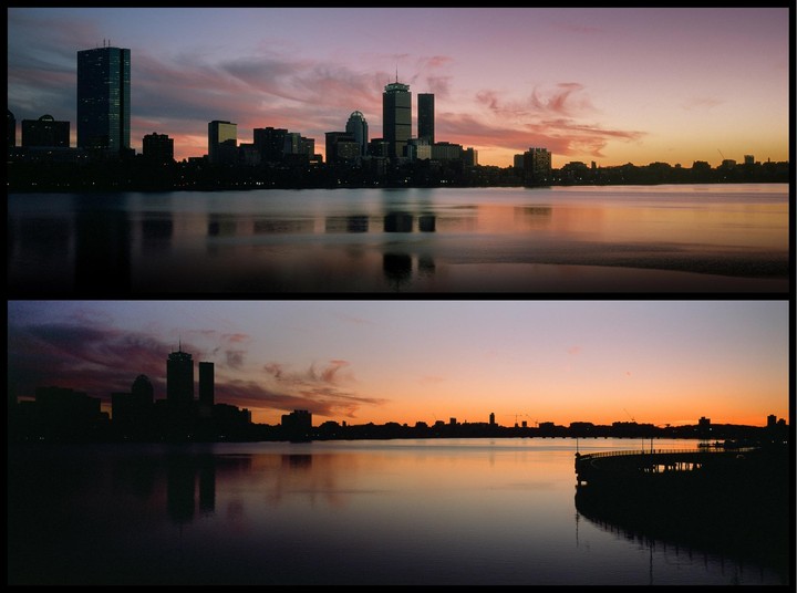 A panoramic view of the Boston skyline at sunset, with the city lights reflecting on the water.