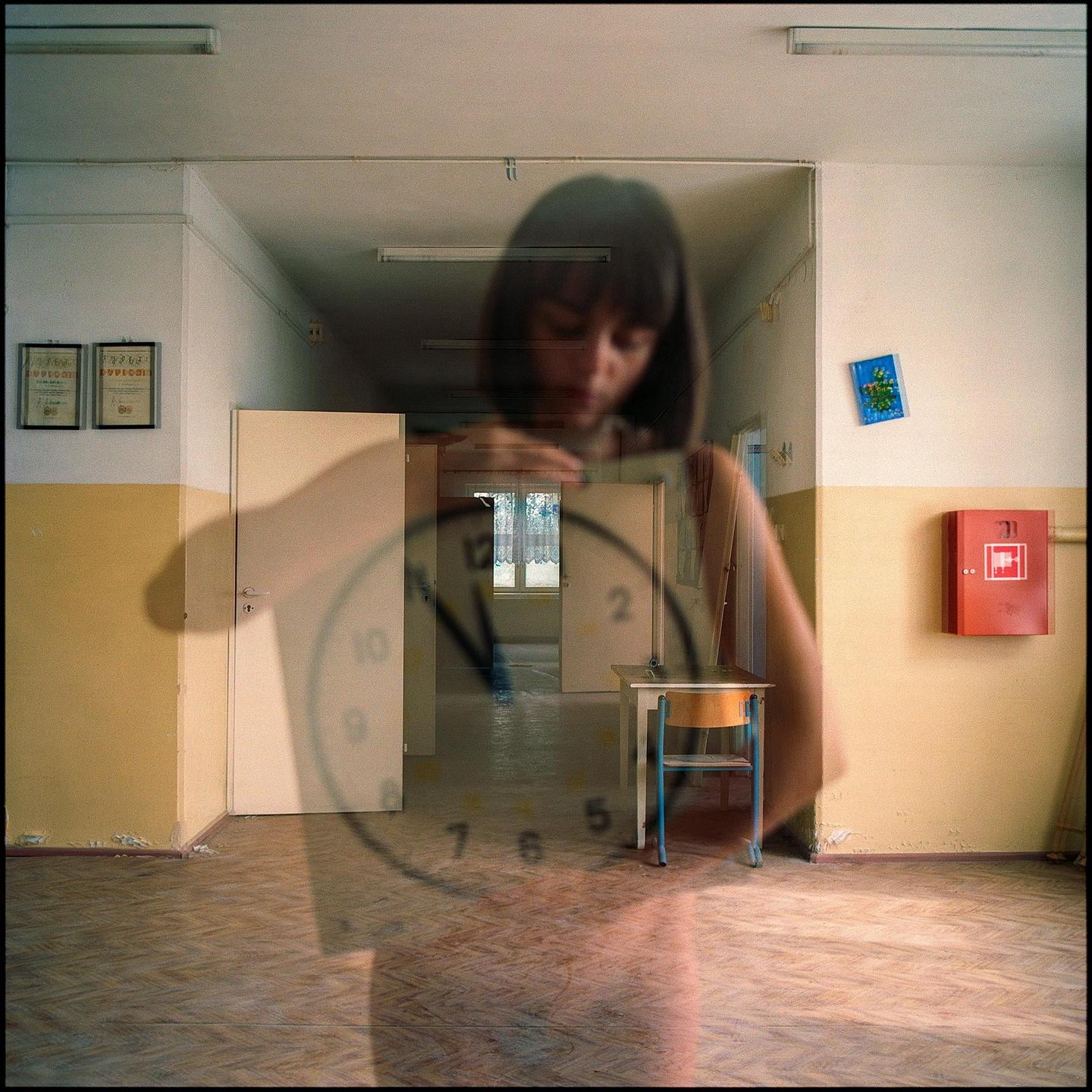 A woman's face is superimposed over a school hallway with a clock face visible in the foreground.