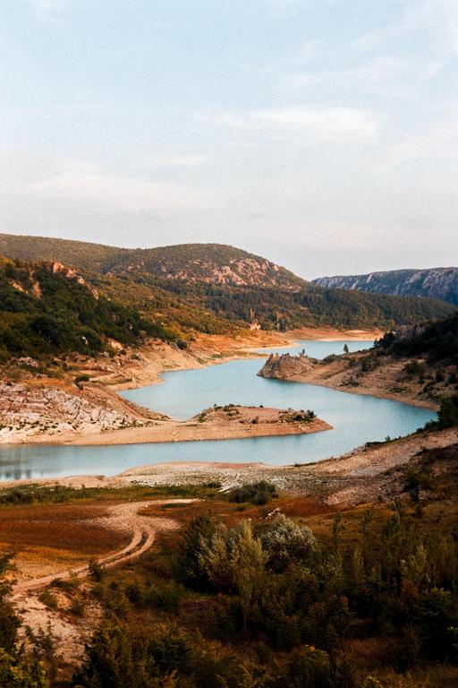 A winding river flows through a valley surrounded by hills and mountains.