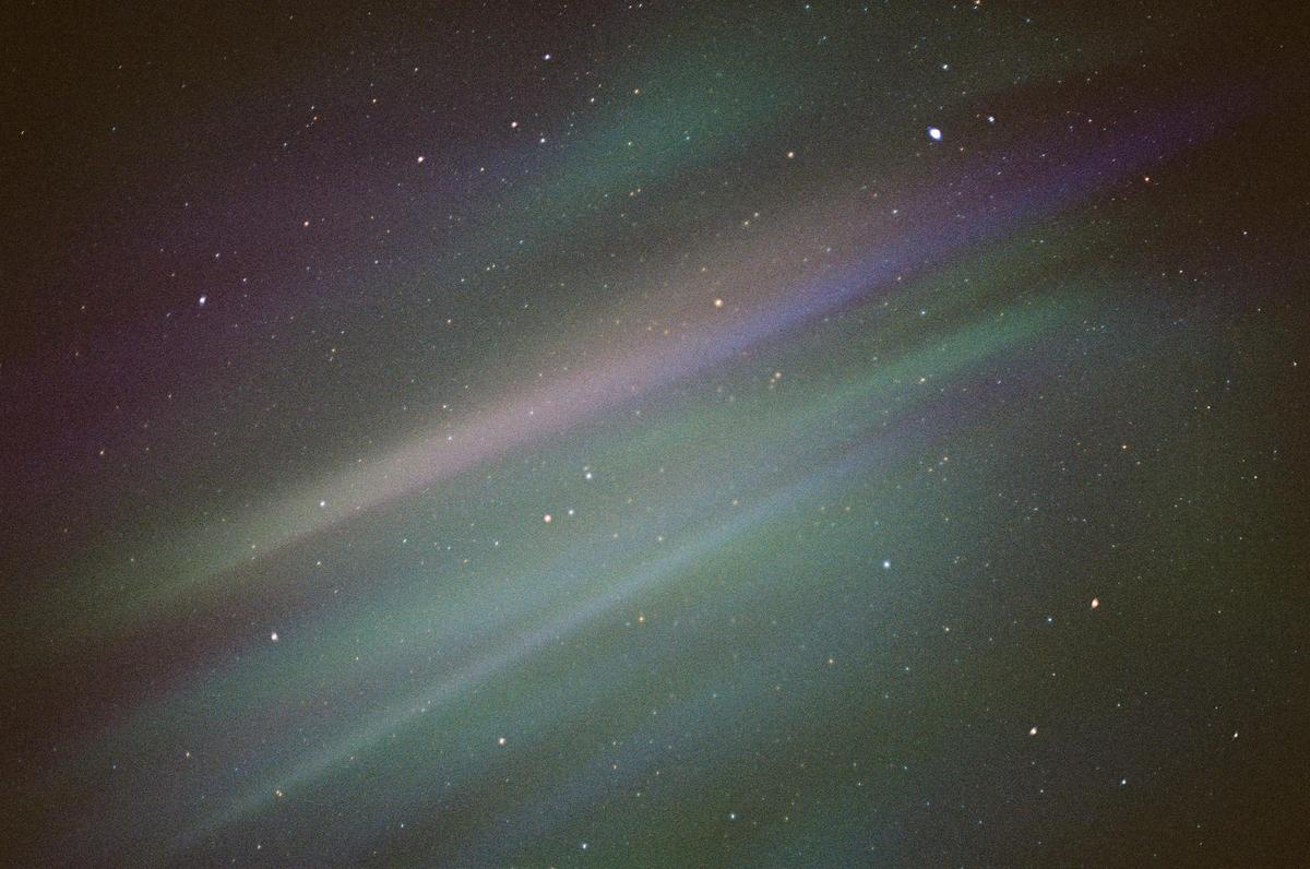 The night sky is filled with numerous stars and colorful bands of aurora borealis.